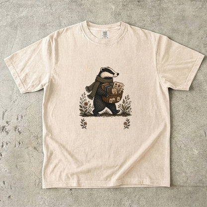 Off to Read Somewhere Quiet badger reading T-shirt in Ivory featuring a scarfed badger carrying books and tea