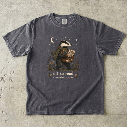 Off to Read Somewhere Quiet badger reading T-shirt in Pepper featuring a scarfed badger carrying books and tea