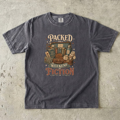 Packed for a Weekend in Fiction reading T-shirt in Pepper featuring a vintage suitcase packed with books, a mug, thermos and cozy socks