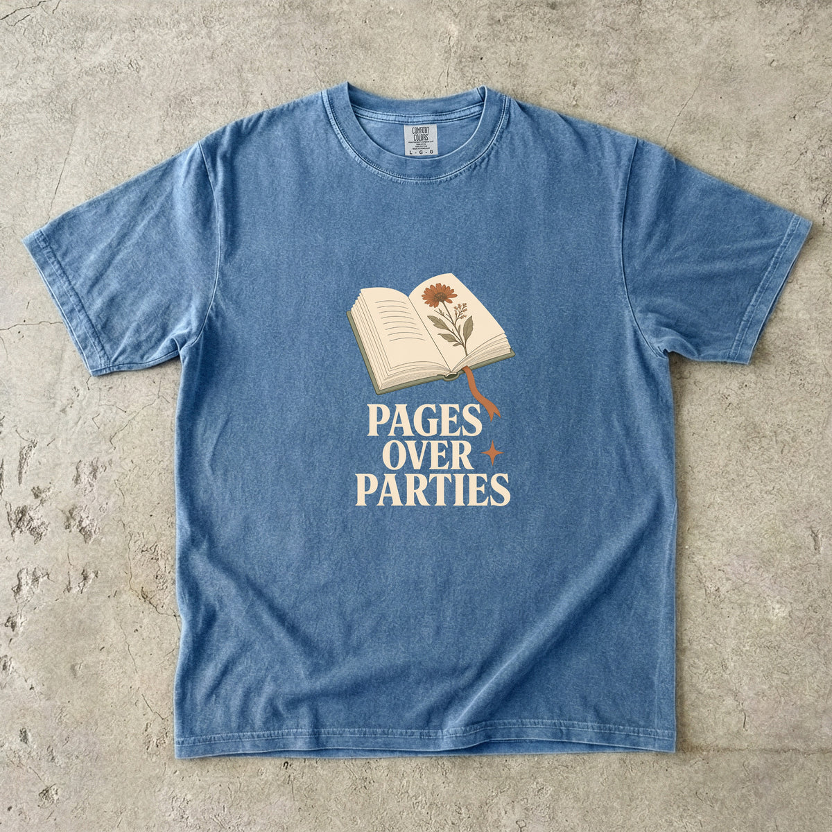 Pages Over Parties introvert reader shirt in Blue Jean with open book and pressed flower artwork for homebody readers.