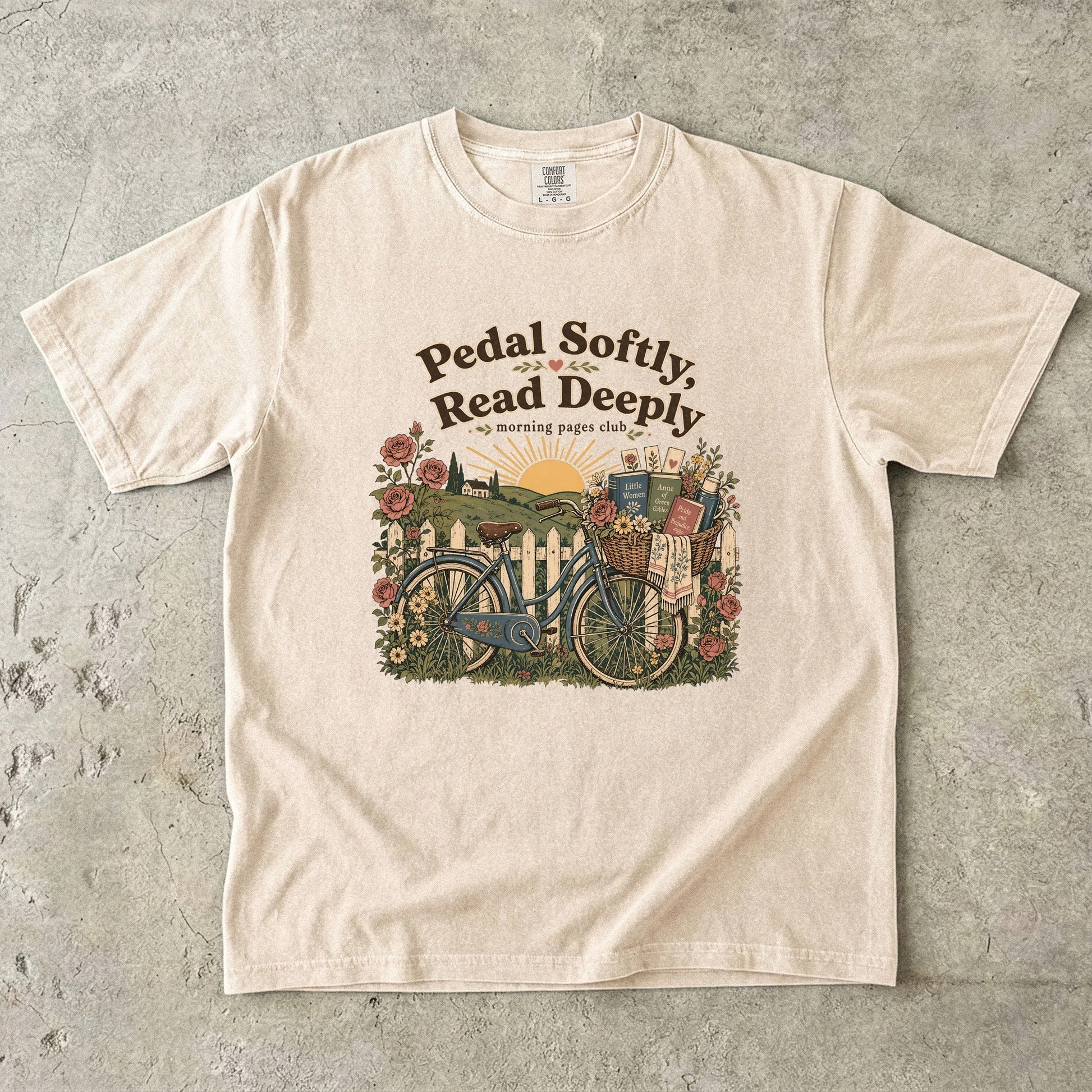 Pedal Softly, Read Deeply book lover T-shirt with vintage bicycle, books and flowers on Ivory.