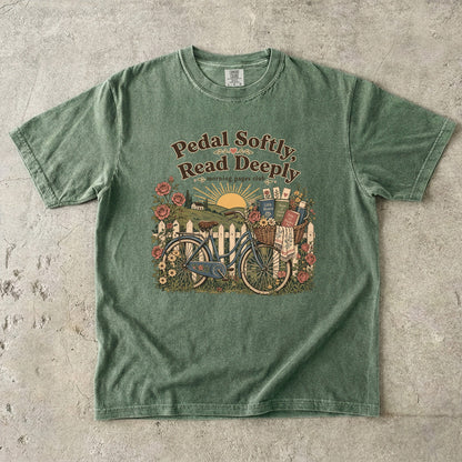 Pedal Softly, Read Deeply book lover T-shirt with vintage bicycle, books and flowers on Moss.
