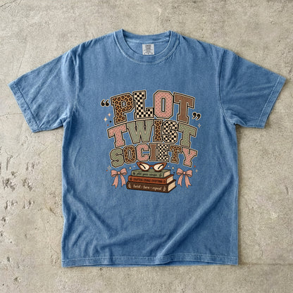 Blue Jean Comfort Colors Plot Twist Society bookish T-shirt with patterned lettering, books, glasses and bow details.