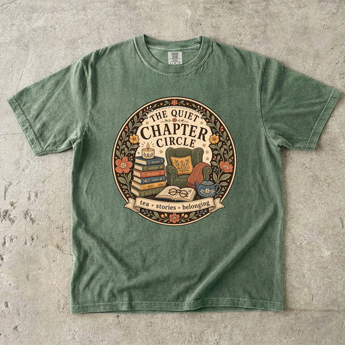 Quiet Chapter Circle book club T-shirt with armchair, stacked books, teapot and floral reading design on Moss.