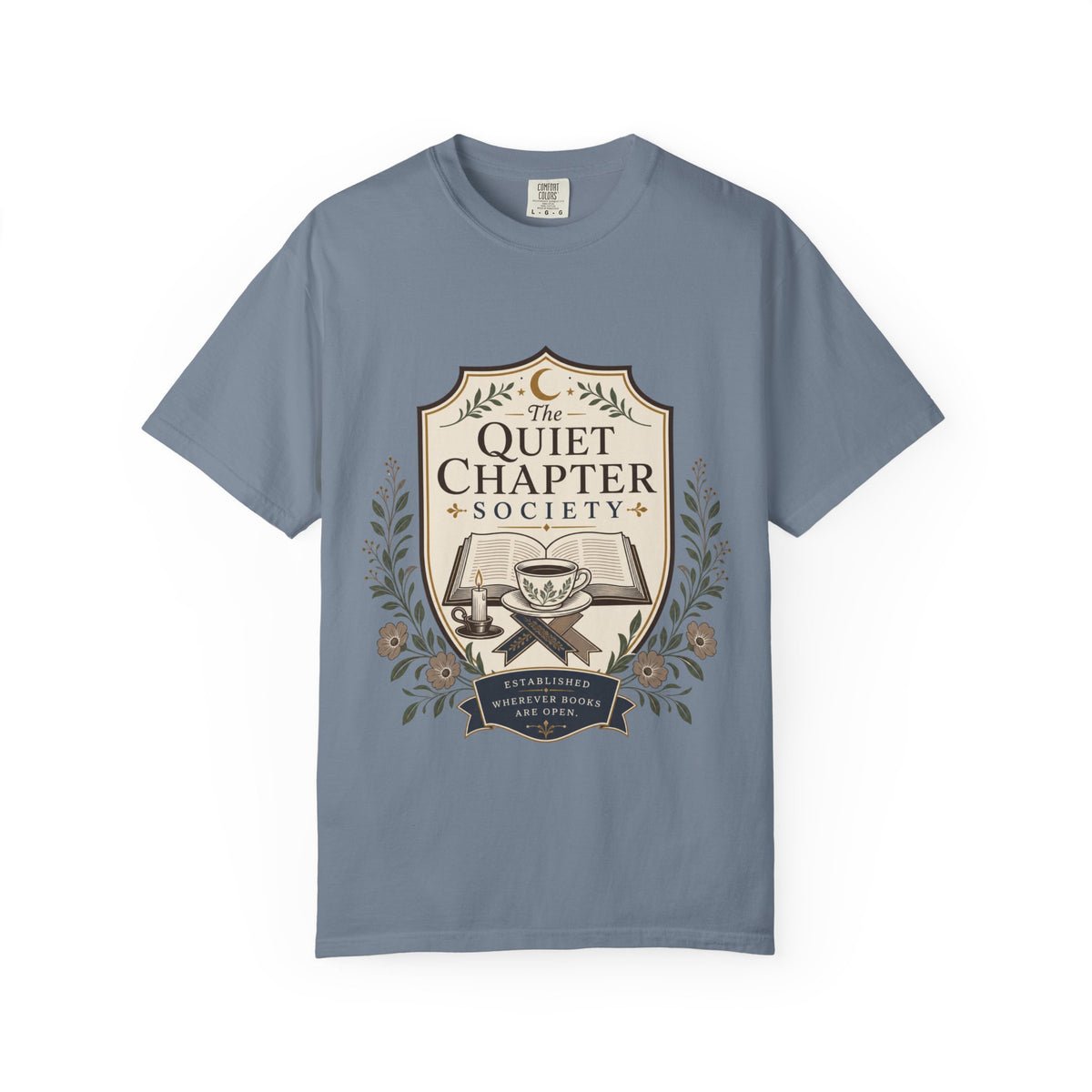 The Quiet Chapter Society book lover T-shirt featuring an open book, teacup, candle and botanical details on Blue Jean.