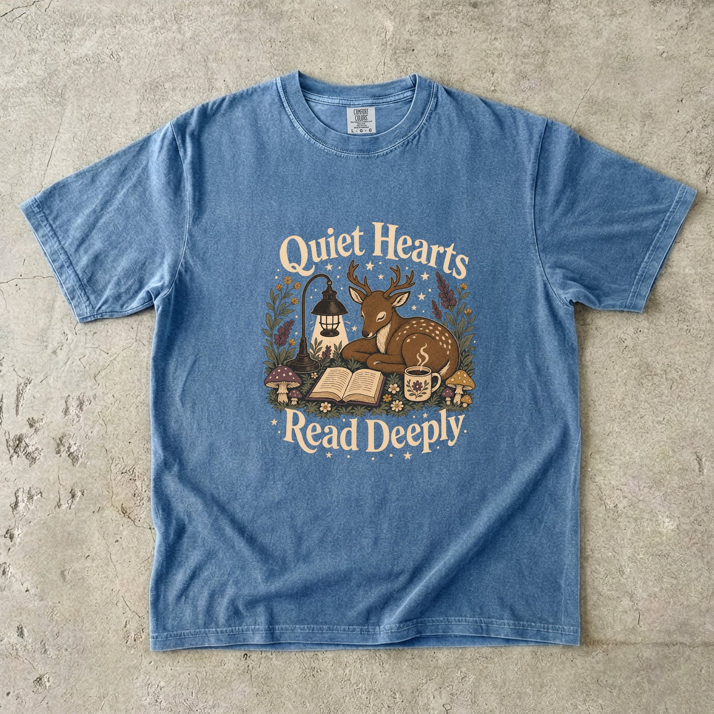 Front view of the Blue Jean Comfort Colors® Book Lover T-shirt featuring a vintage woodland deer, book and tea illustration.