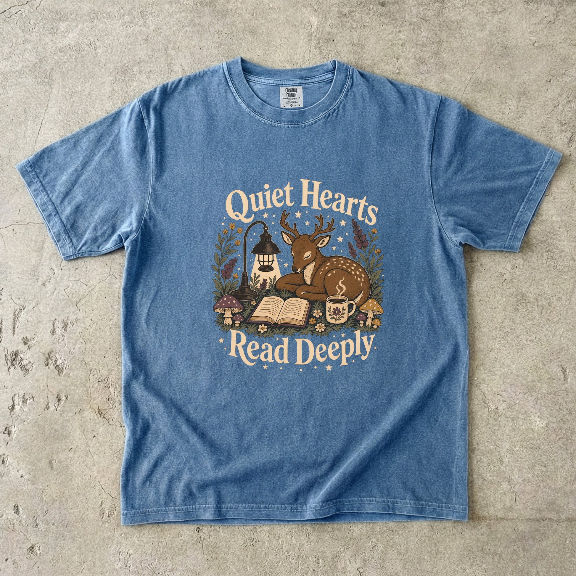 Front view of the Blue Jean Comfort Colors® Book Lover T-shirt featuring a vintage woodland deer, book and tea illustration.
