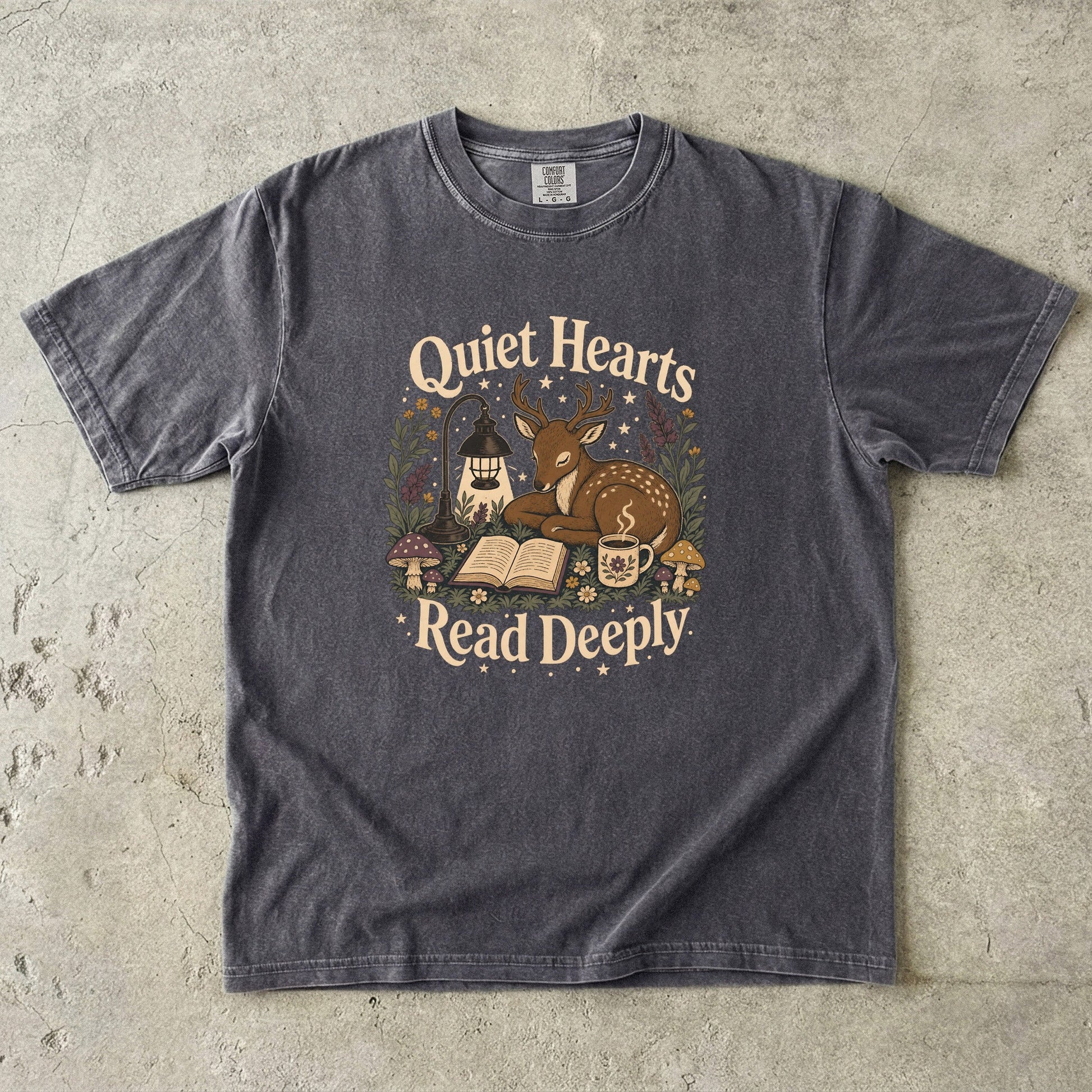 Front view of the Pepper Comfort Colors® Book Lover T-shirt featuring the Quiet Hearts Read Deeply woodland reading illustration.