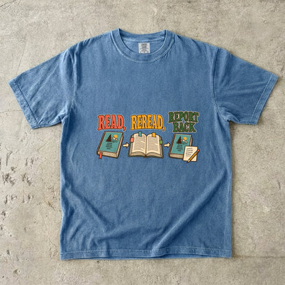 Blue Jean book club T-shirt with “Read, Reread, Report Back” above three illustrated book moments