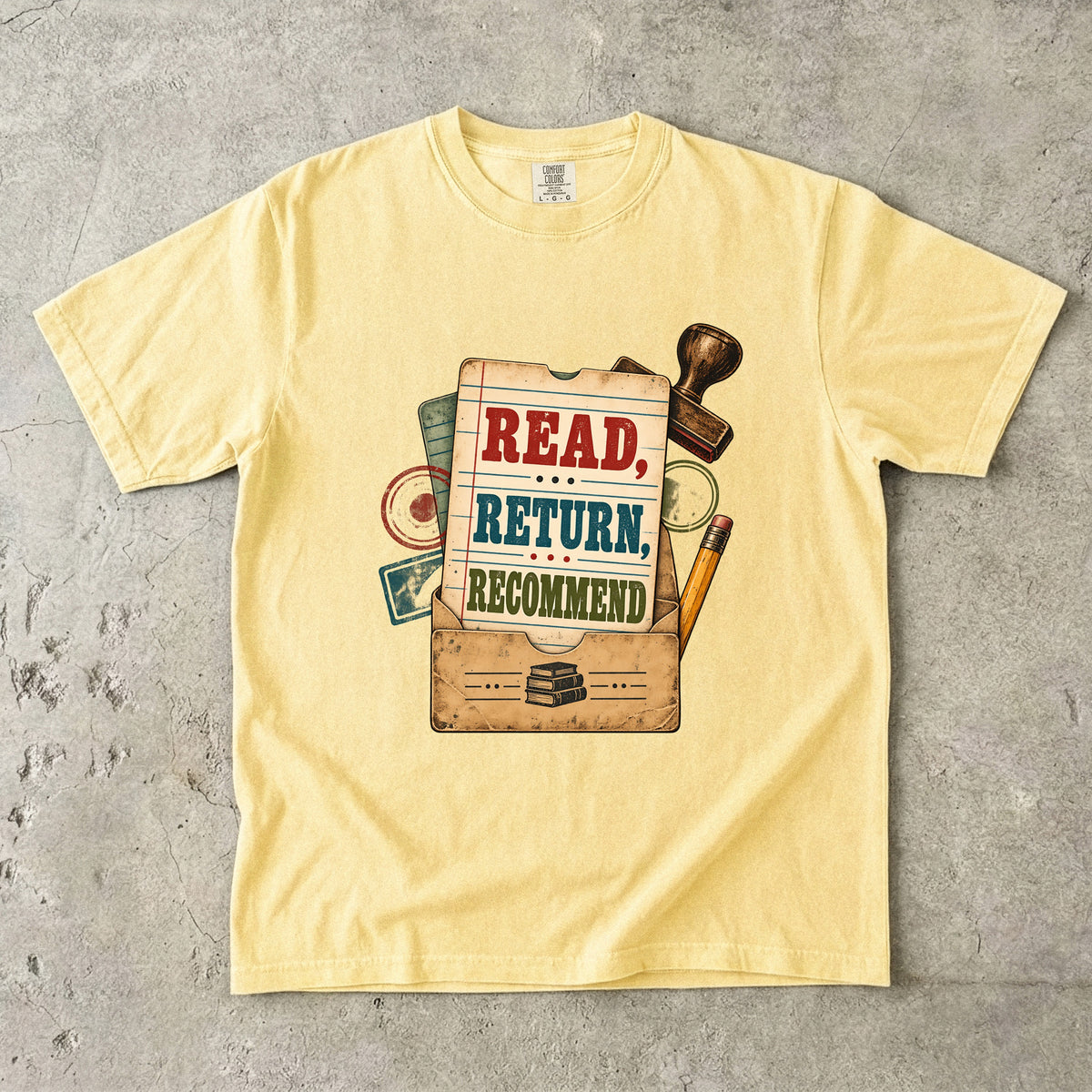 Butter library lover T-shirt with “Read, Return, Recommend” on a vintage library-style card