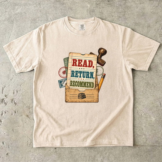Ivory library lover T-shirt with “Read, Return, Recommend” on a vintage library-style card