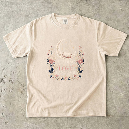 Ivory book lover T-shirt featuring Reading Is My Love Language with an open book, crescent moon, stars and pink floral details.