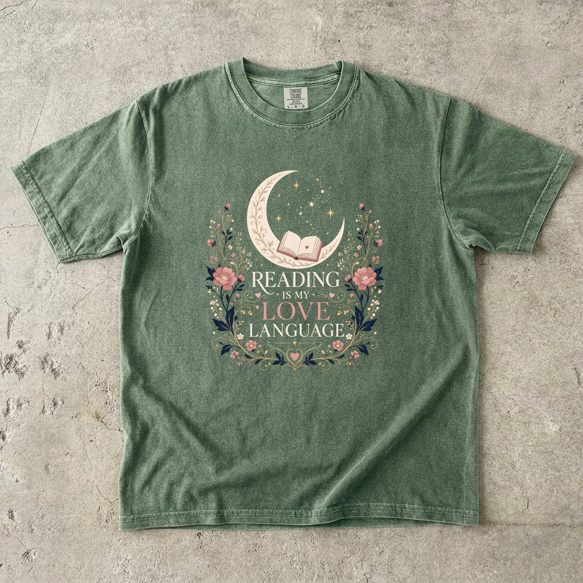 Moss book lover T-shirt featuring Reading Is My Love Language with an open book, crescent moon, stars and pink floral details.
