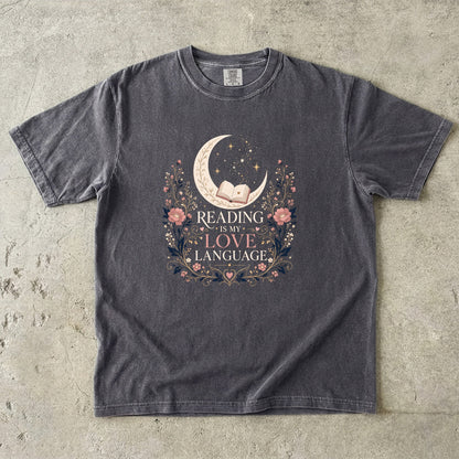 Pepper book lover T-shirt featuring Reading Is My Love Language with an open book, crescent moon, stars and pink floral details.