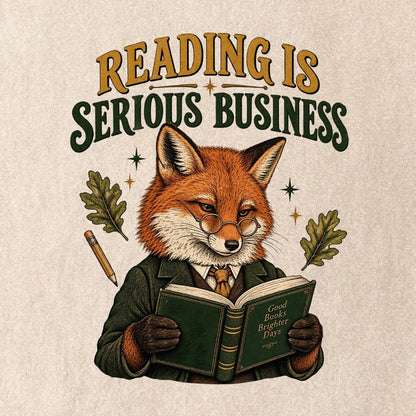 Close-up of the “Reading Is Serious Business” T-shirt design, showing a fox in glasses and a green jacket reading an open book, with a pencil, oak leaves and stars.