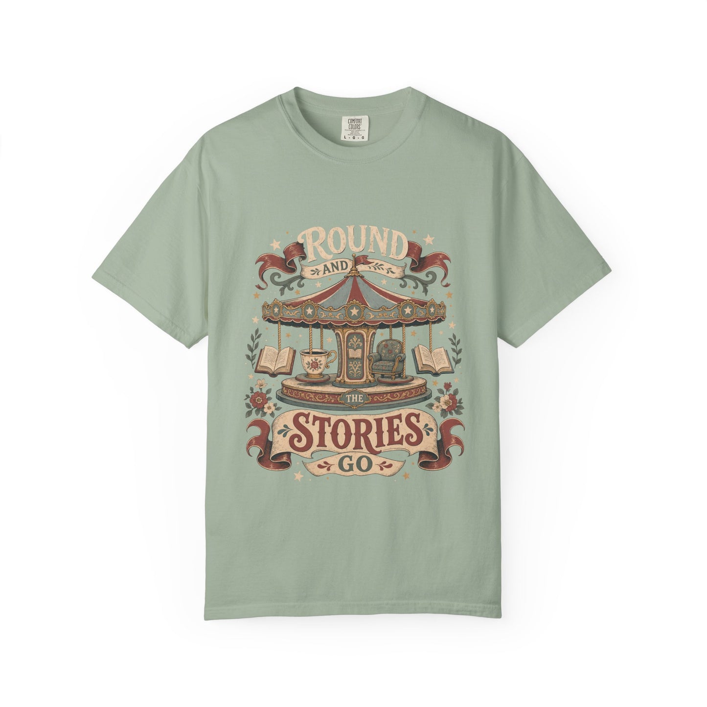 Front view of a Bay Comfort Colors® book lover T-shirt featuring the "Round and Round the Stories Go" vintage carousel, books, teacup and reading chair illustration.
