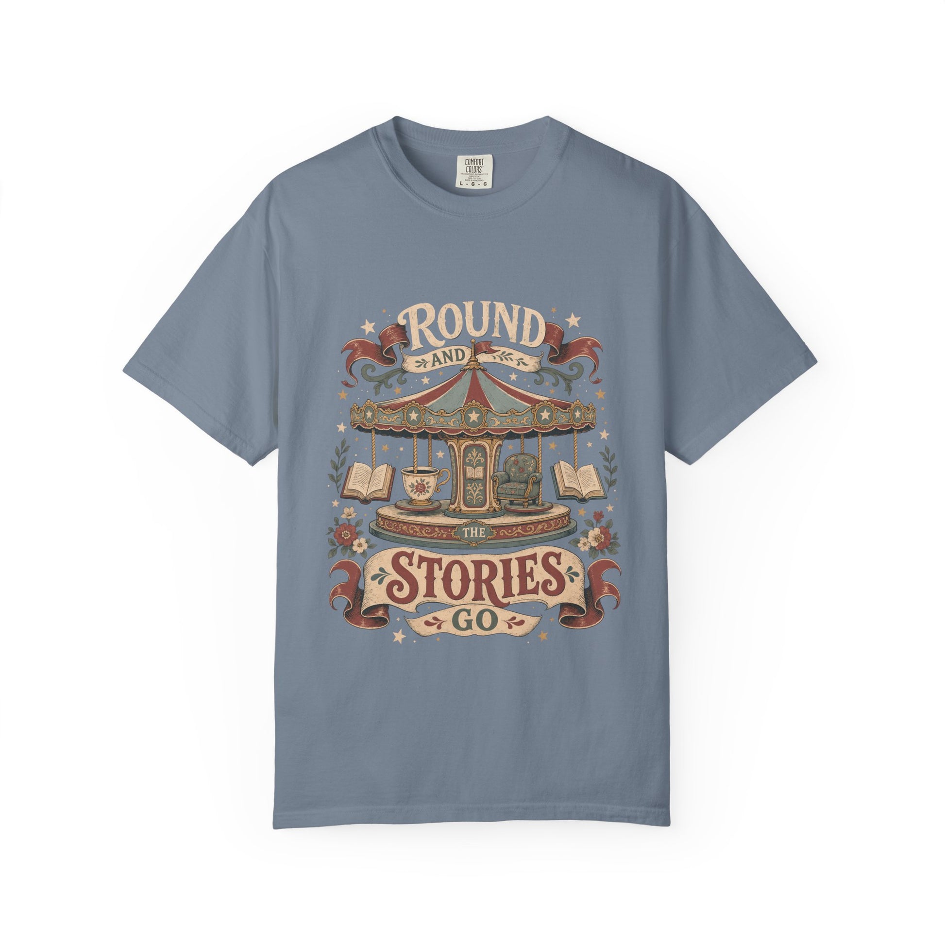 Front view of a Blue Jean Comfort Colors® book lover T-shirt featuring the "Round and Round the Stories Go" vintage carousel, books, teacup and reading chair illustration.