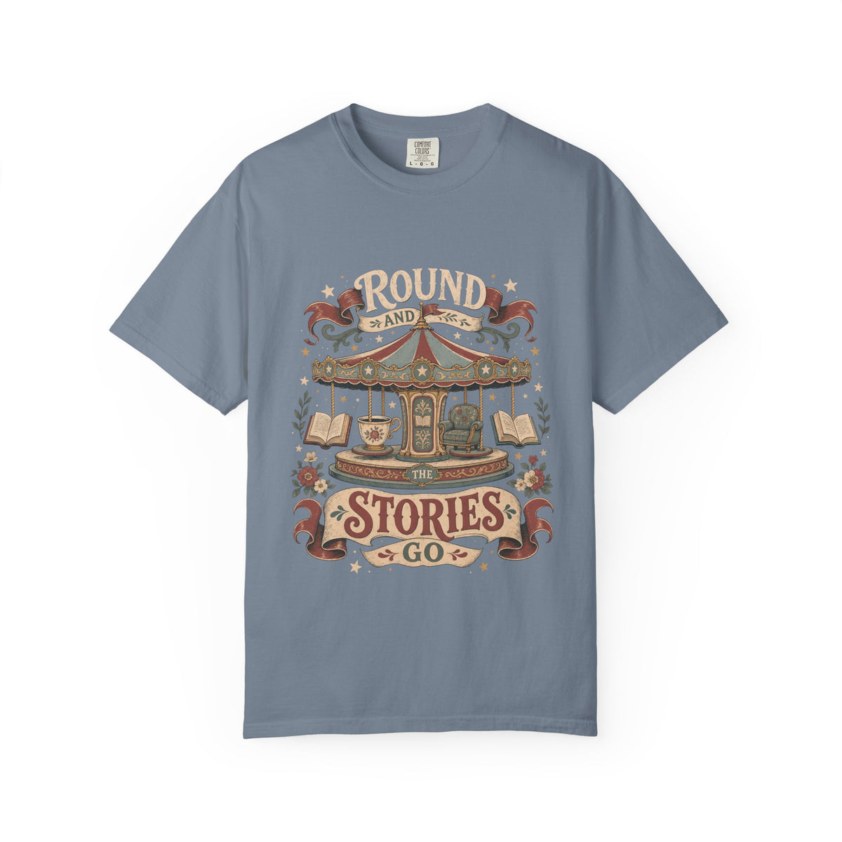 Round and Round the Stories Go book lover T-shirt in Blue Jean featuring a vintage carousel with open books, reading chair and teacup