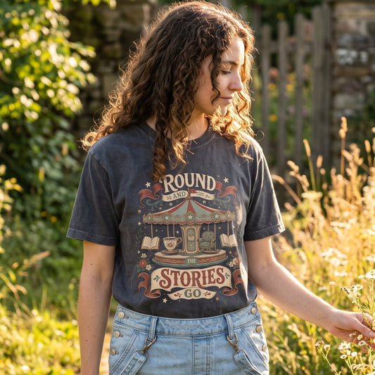 Woman wearing the Round and Round the Stories Go Comfort Colors® book lover shirt showcasing the whimsical vintage carousel, books and teacup illustration.