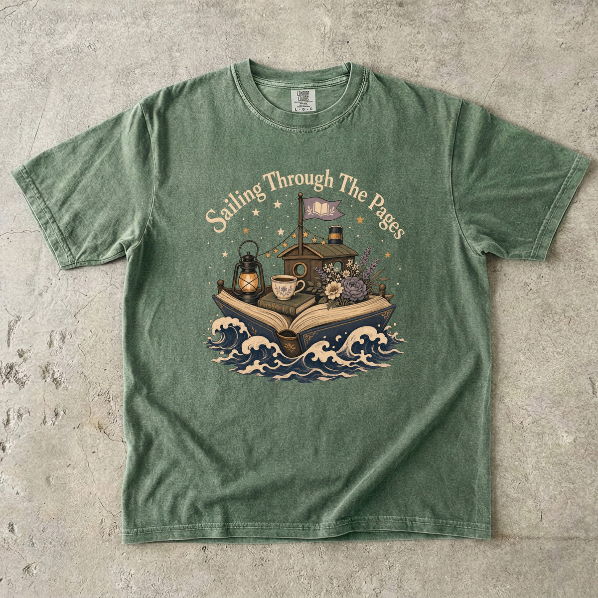 Sailing Through the Pages literary T-shirt in Moss featuring an open book sailing through waves with flowers and lantern