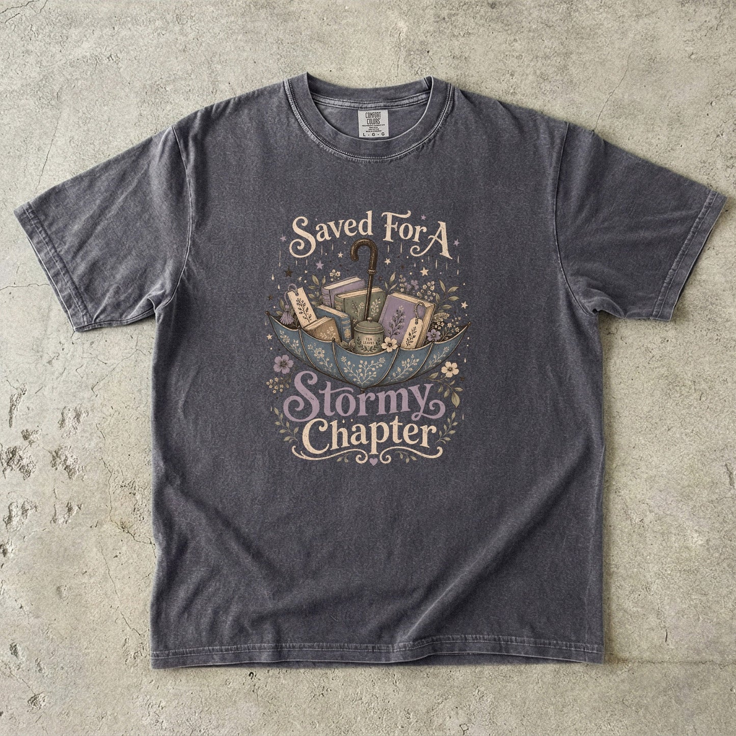 Saved for a Stormy Chapter reading T-shirt in Pepper featuring an umbrella filled with books, tea, bookmarks and flowers