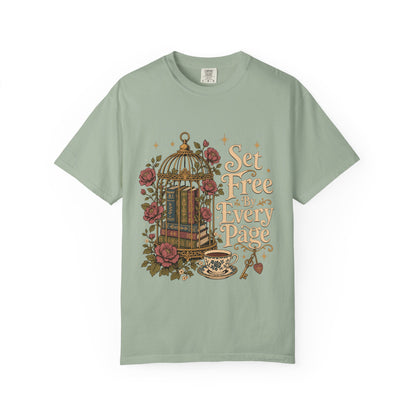 Front view of a Bay Comfort Colors T-shirt featuring the "Set Free By Every Page" vintage literary design with books inside an ornate birdcage, roses, teacup and decorative key.