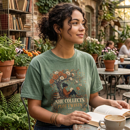 She Collects Plot Twists and Paperbacks reading T-shirt featuring a reader beneath a flowering tree surrounded by books and leaves.