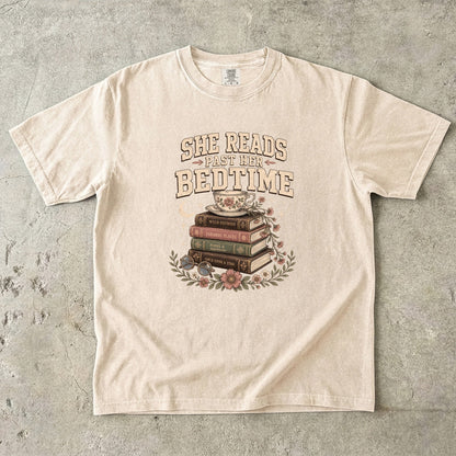 Ivory reading T-shirt featuring She Reads Past Her Bedtime with stacked books, a floral teacup, flowers and crescent moon.