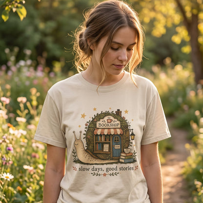 Woman wearing the Slow Days, Good Stories Book Lover Shirt on an Ivory Comfort Colors 1717 T-shirt in a woodland garden setting.

