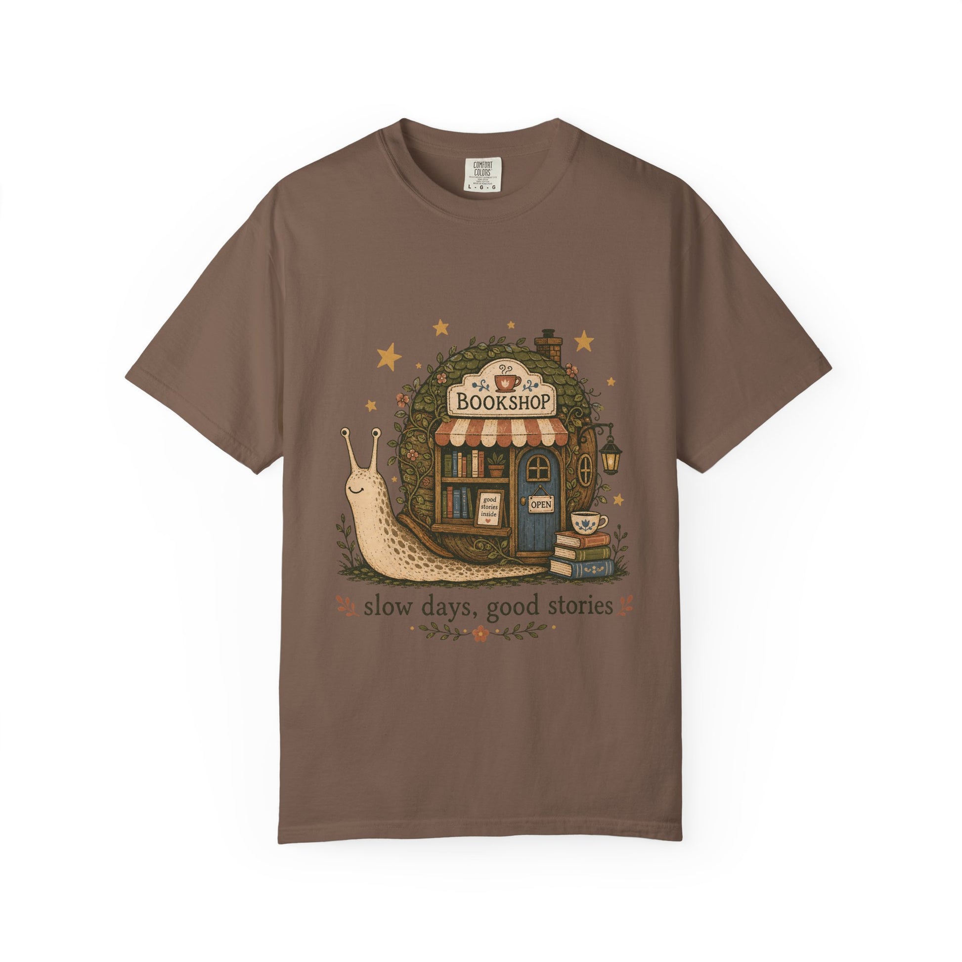 Slow Days, Good Stories bookshop T-shirt in Espresso featuring a snail beside a tiny bookshop with books and tea