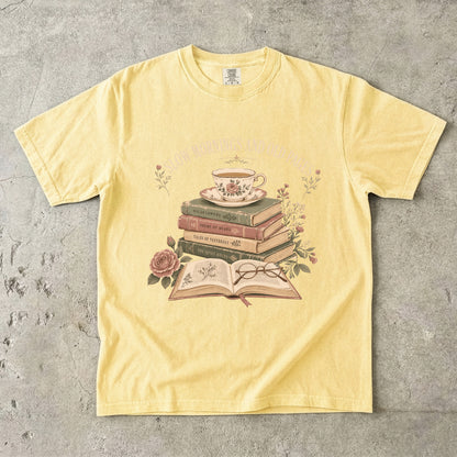 Butter reading T-shirt featuring Slow Mornings and Old Pages with stacked vintage books, a floral teacup, open book, glasses and roses.