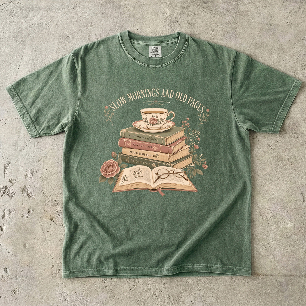 Moss reading T-shirt featuring Slow Mornings and Old Pages with stacked vintage books, a floral teacup, open book, glasses and roses.