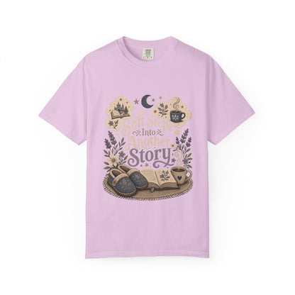 Soft Steps Into Another Story book lover shirt on a Comfort Colors orchid T-shirt featuring vintage-inspired artwork with books, cosy slippers, flowers and coffee mugs.

