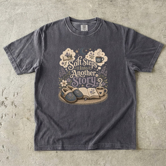 Soft Steps Into Another Story cozy reading T-shirt in Pepper featuring slippers, an open book, flowers and a warm drink
