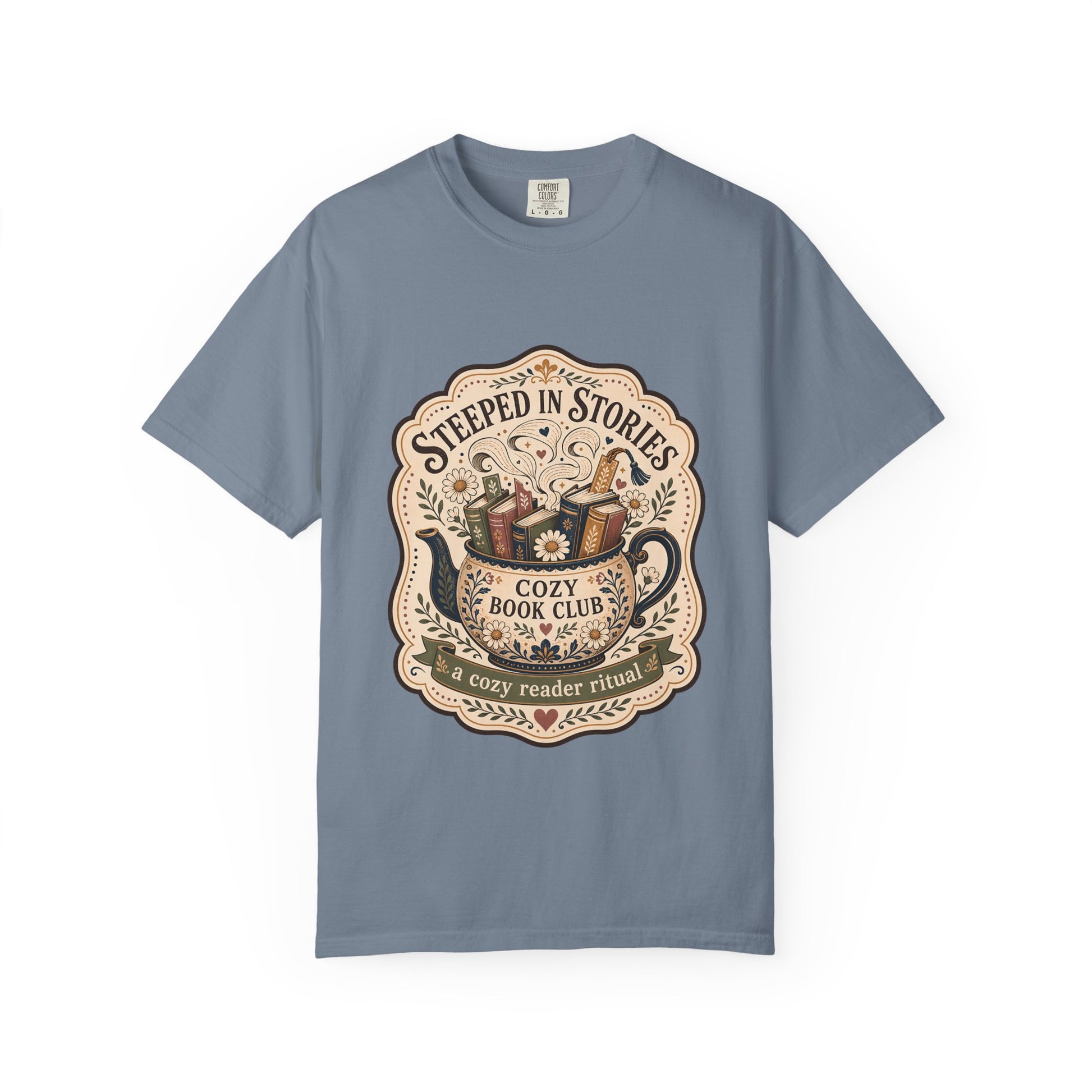 Steeped in Stories book lover T-shirt with a floral teapot overflowing with books on Blue Jean.