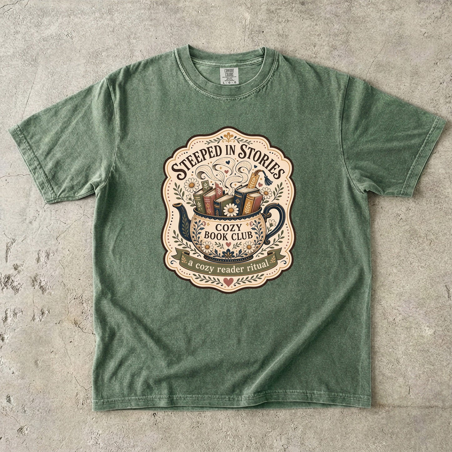 Steeped in Stories book lover T-shirt with a floral teapot overflowing with books on Moss.