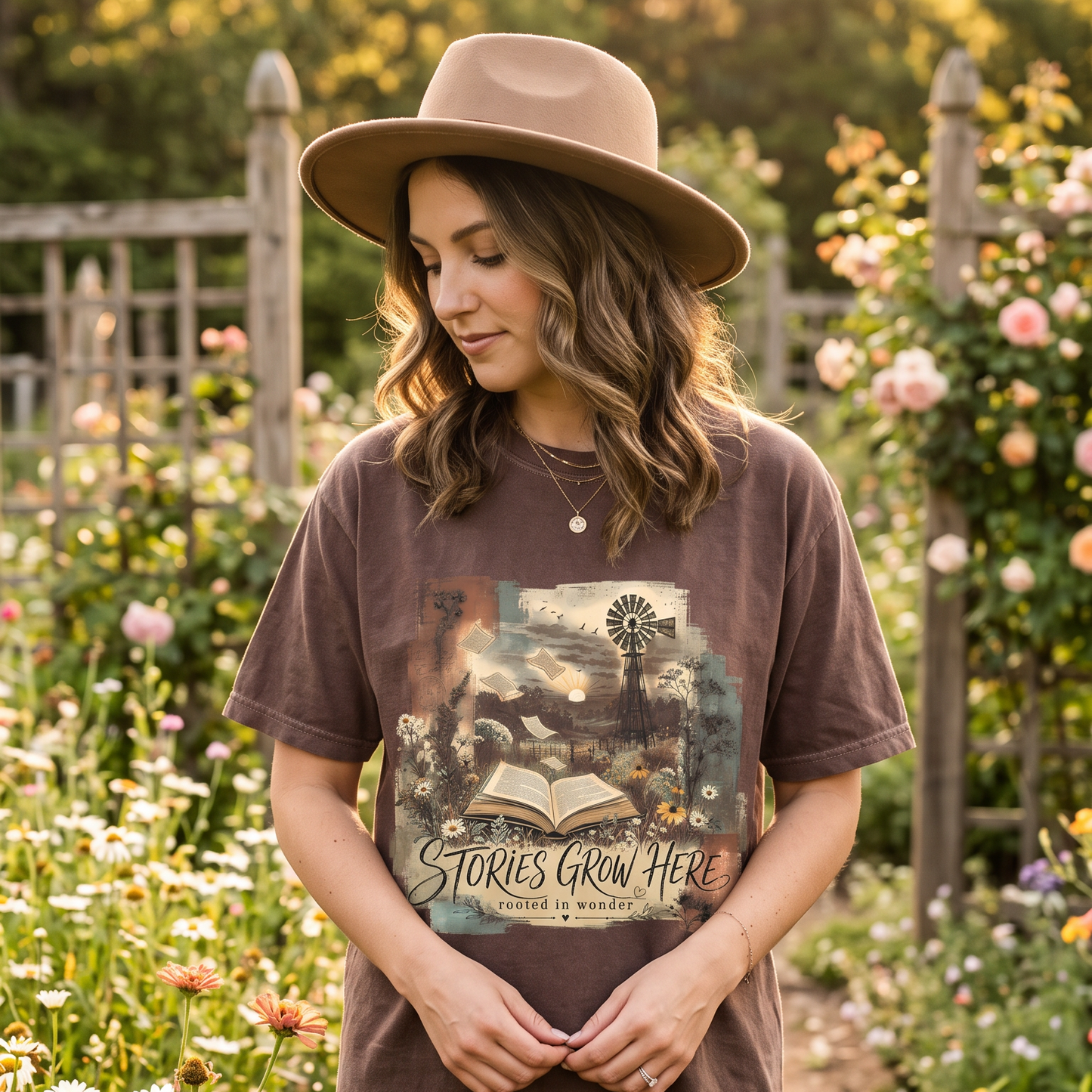 Woman wearing an Espresso Stories Grow Here book lover T-shirt in a flower garden.