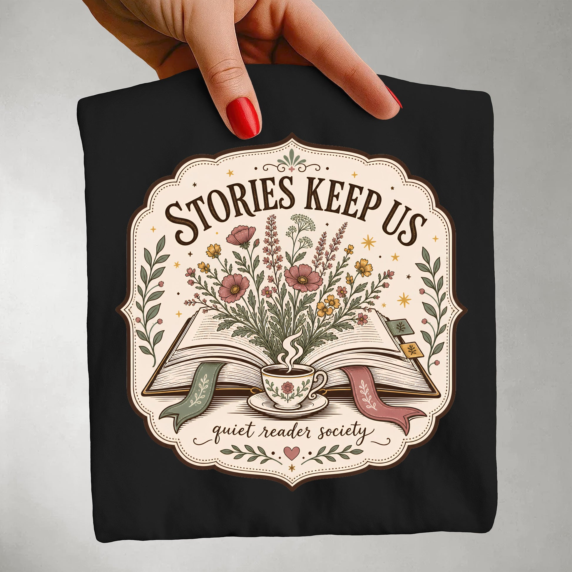 Folded black Stories Keep Us literary graphic T-shirt featuring vintage book-inspired artwork.