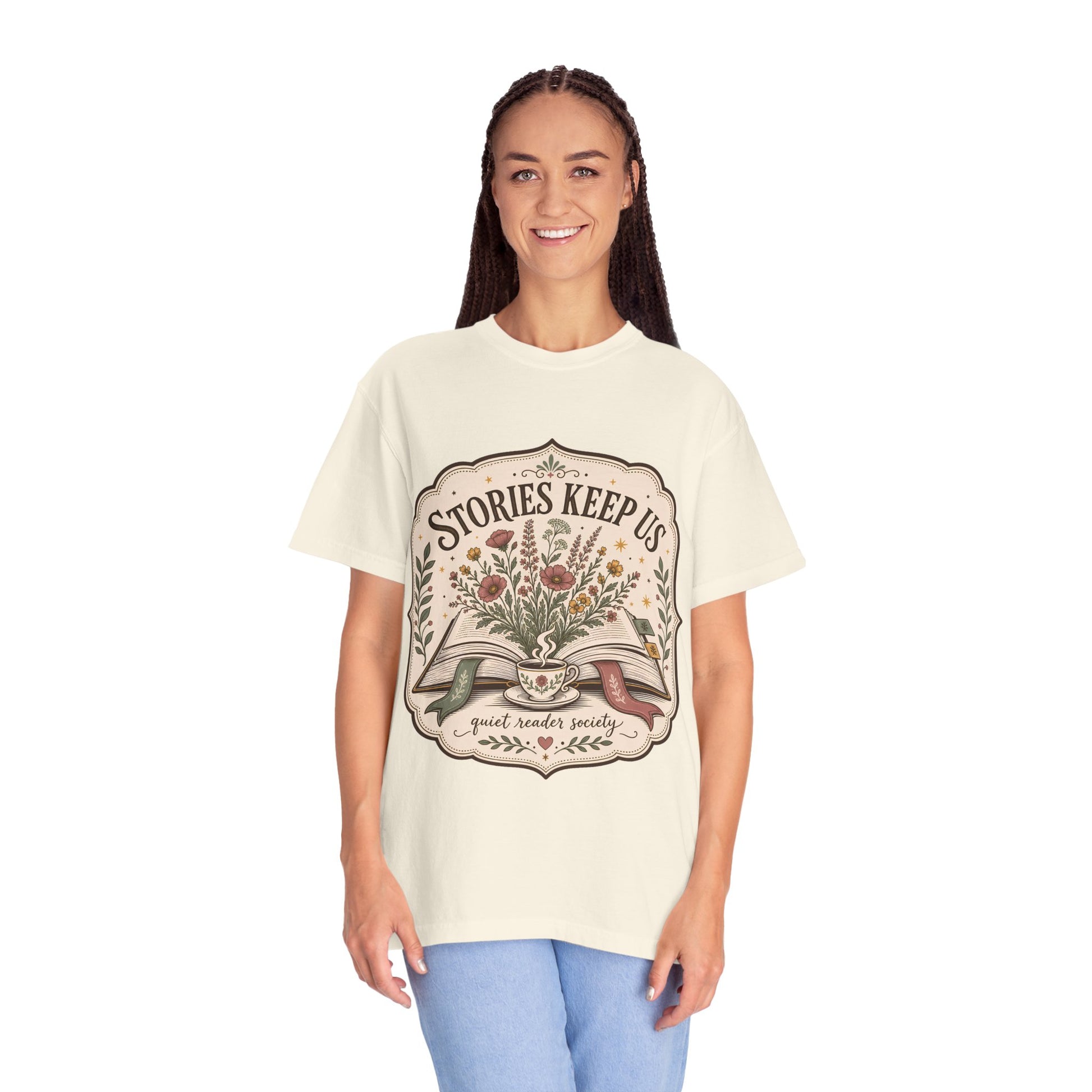 Woman wearing the Stories Keep Us vintage book lover T-shirt in ivory while enjoying a quiet reading moment.