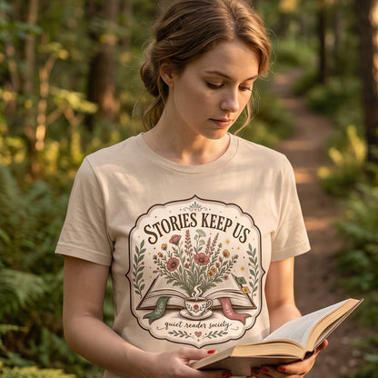 Stories Keep Us Quiet Reader Society shirt featuring an open book, wildflowers and a floral teacup.