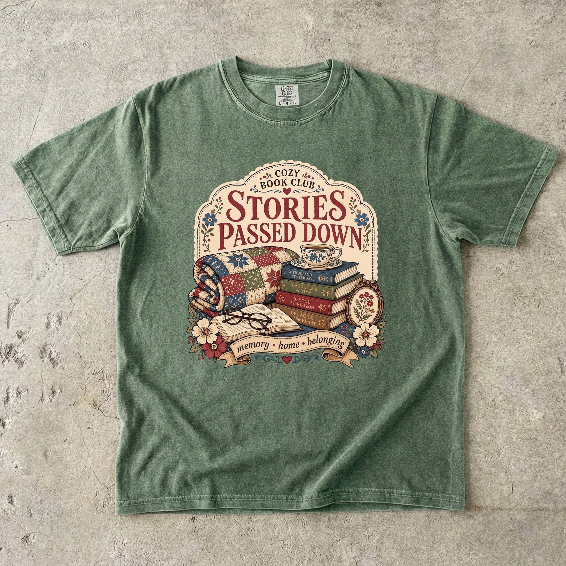 Stories Passed Down literary T-shirt with books, a patchwork quilt and floral keepsakes on Moss.