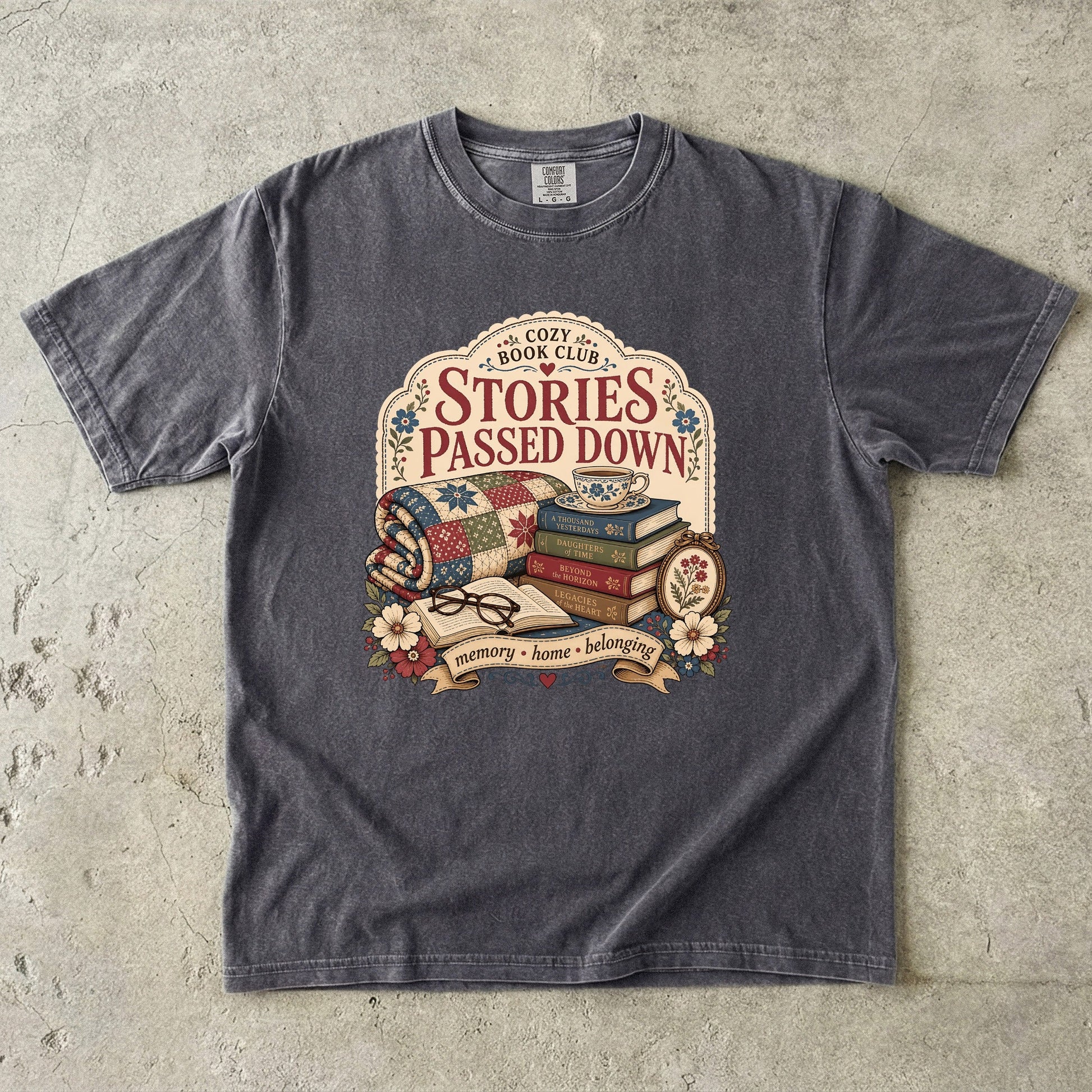 Stories Passed Down literary T-shirt with books, a patchwork quilt and floral keepsakes on Pepper.