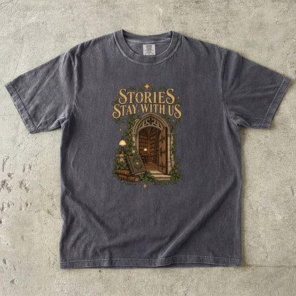 Pepper T-shirt featuring “Stories Stay With Us” with an ivy-covered arched library doorway, antique books, lamps and gold stars.