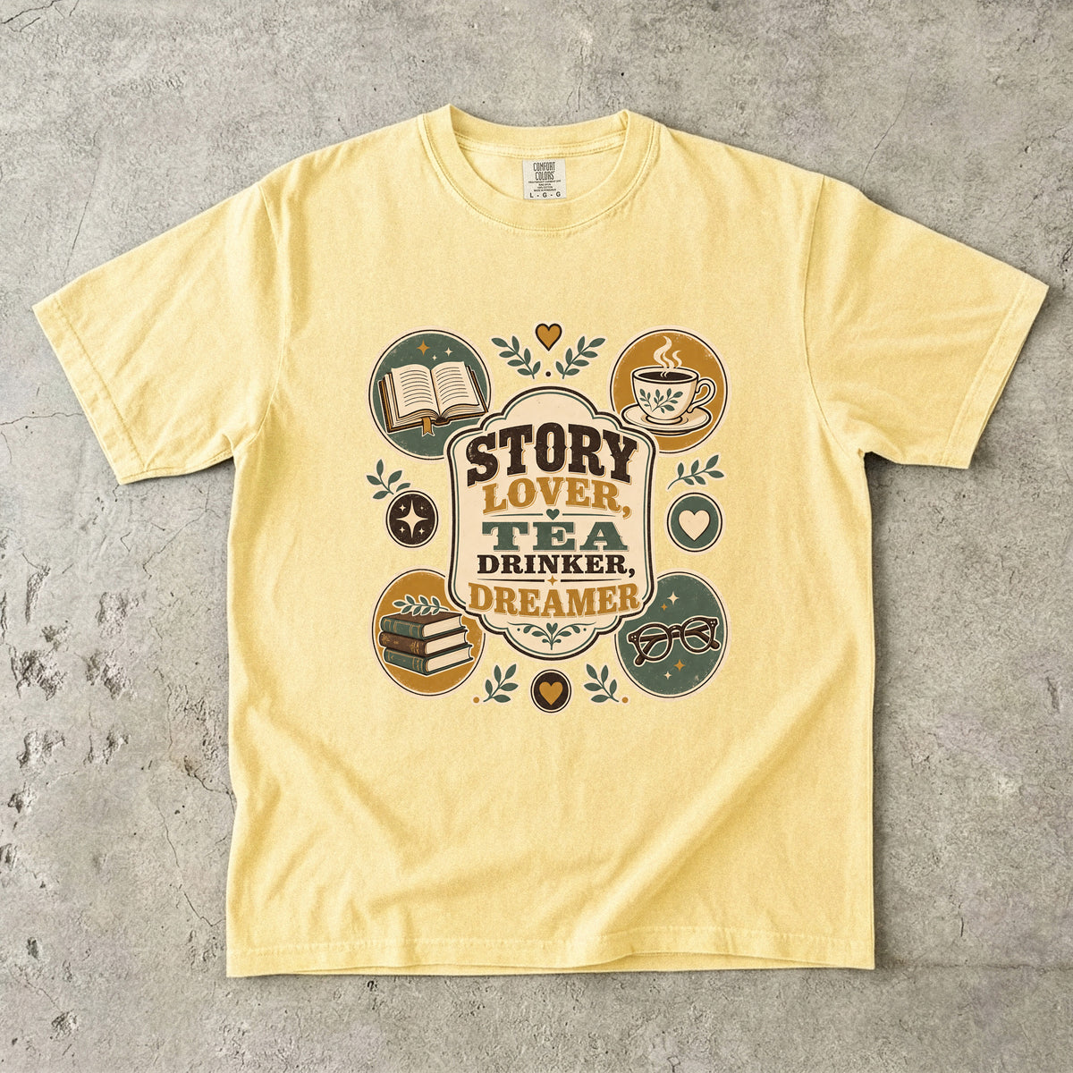 Story Lover Tea Drinker Dreamer book lover shirt in Butter with a teacup, books and nostalgic reading illustrations.