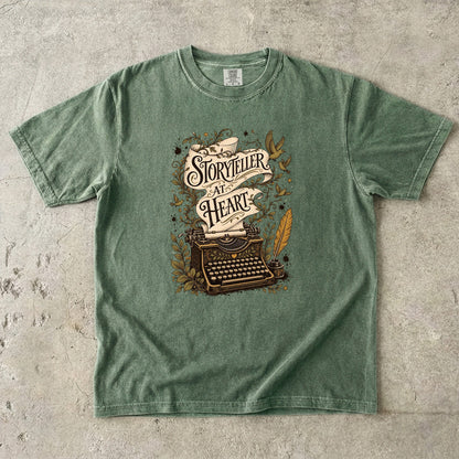 Storyteller at Heart writer shirt in Moss featuring a vintage typewriter, quill, birds and leafy literary illustration.