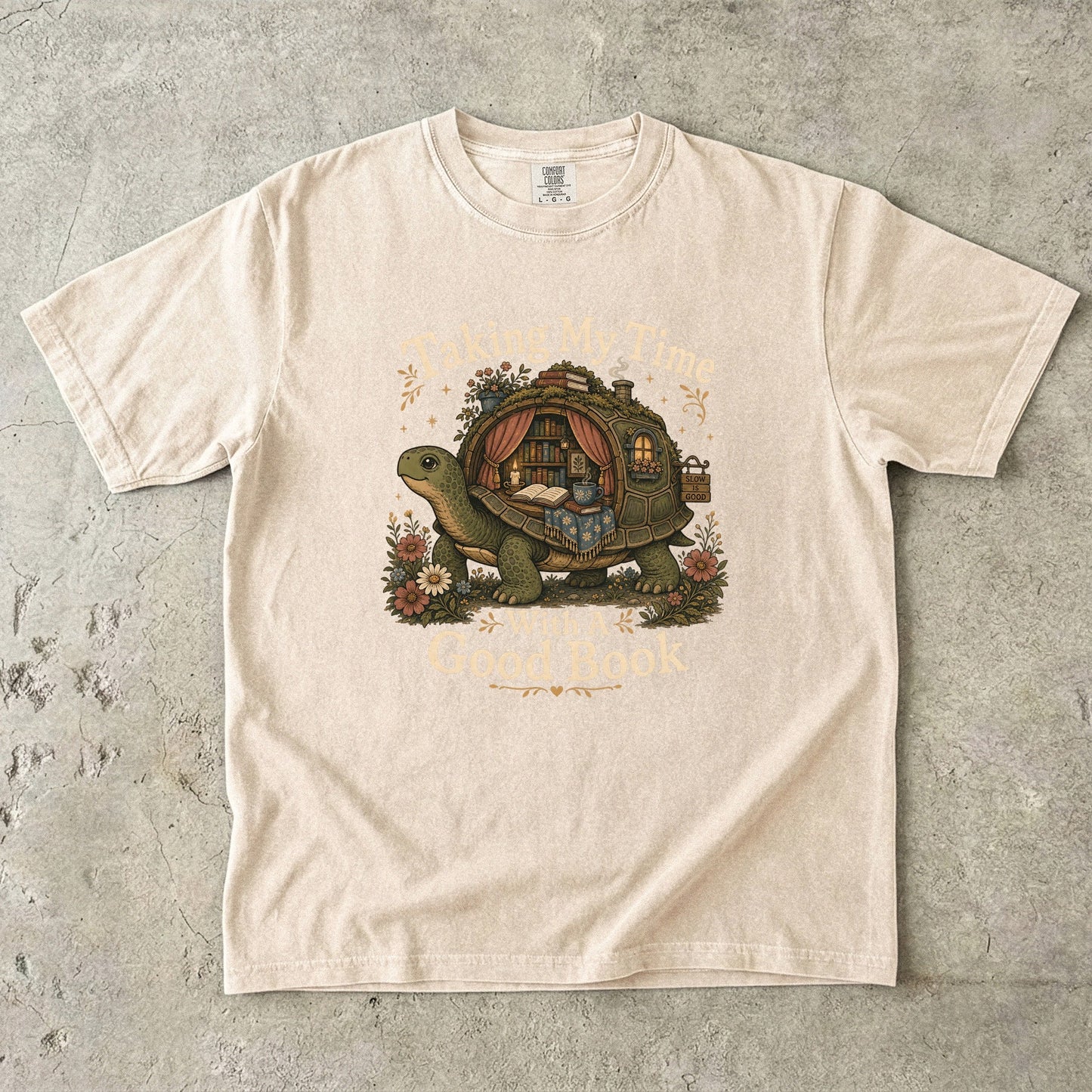 Taking My Time With a Good Book T-shirt in Ivory featuring a tortoise carrying a cozy book-filled reading retreat