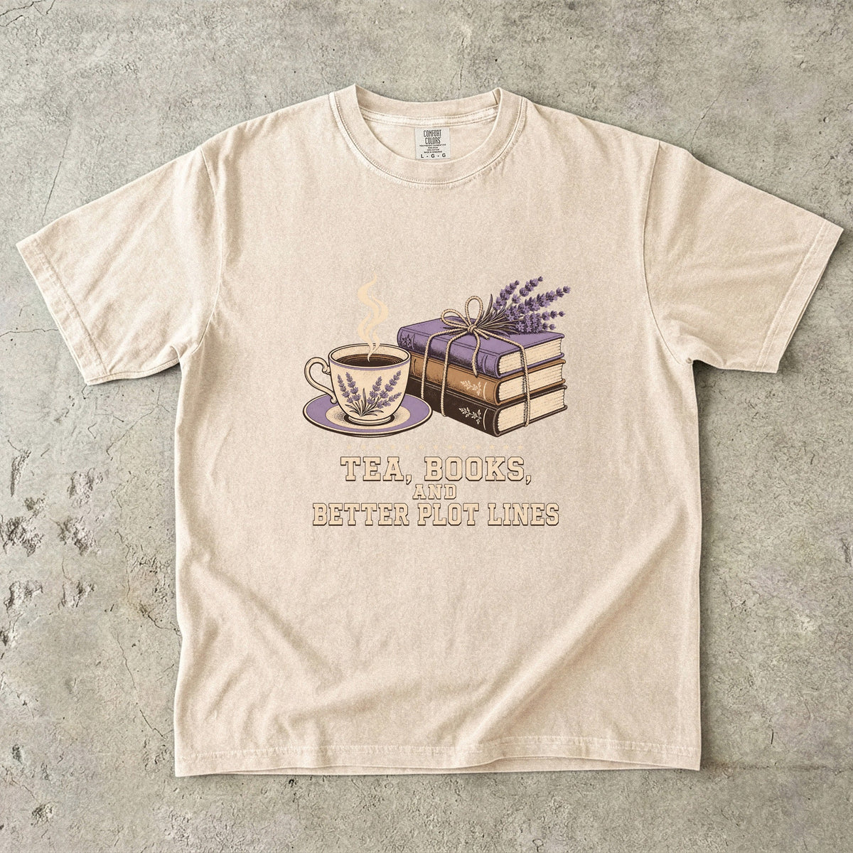 Ivory reading T-shirt featuring Tea, Books, and Better Plot Lines with stacked books, a steaming lavender teacup and lavender sprigs.