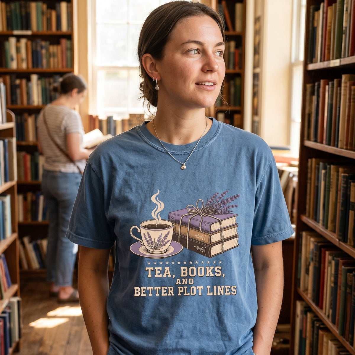 Tea, Books, and Better Plot Lines reading T-shirt with stacked books, a steaming lavender teacup and lavender botanical artwork.