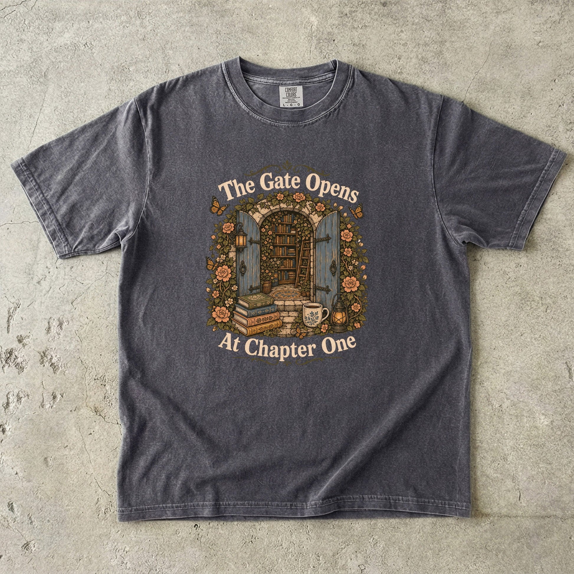 The Gate Opens at Chapter One literary T-shirt in Espresso featuring open blue gates leading into a flower-filled hidden library