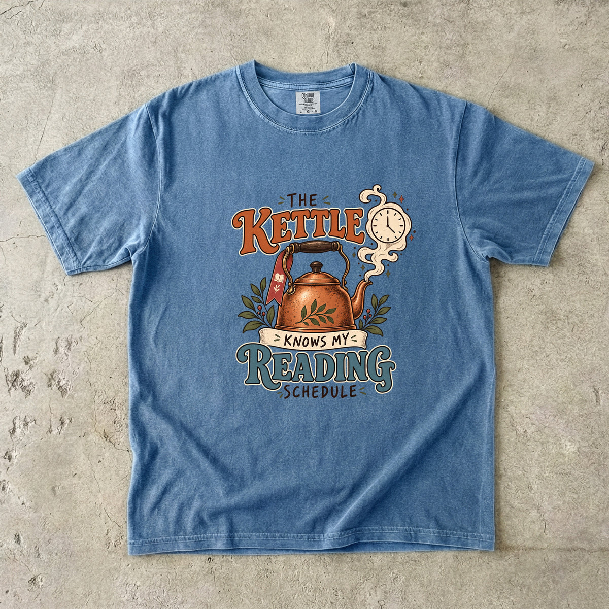 Blue Jean reading T-shirt with “The Kettle Knows My Reading Schedule” and an illustrated copper kettle